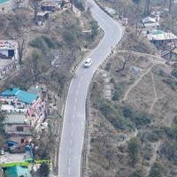 Aerial top view of traffic vehicles driving at mountains roads at Nainital, Uttarakhand, India, View from the top side of mountain for movement of traffic vehicles photo