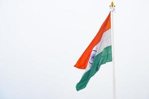 India flag flying high at Connaught Place with pride in blue sky, India flag fluttering, Indian Flag on Independence Day and Republic Day of India, tilt up shot, Waving Indian flag, Har Ghar Tiranga photo