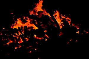 llamas de fuego sobre fondo negro, fondo de textura de llama de fuego blaze, maravillosamente, el fuego está ardiendo, llamas de fuego con madera y hoguera de estiércol de vaca foto