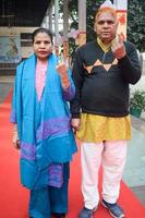 New Delhi, India - December 04 2022 - Unidentified people showing their ink-marked fingers after casting votes in front of polling booth of east Delhi area for MCD local body Elections 2022 photo