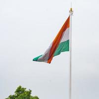 India flag flying high at Connaught Place with pride in blue sky, India flag fluttering, Indian Flag on Independence Day and Republic Day of India, tilt up shot, Waving Indian flag, Har Ghar Tiranga photo