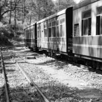 tren de juguete moviéndose en las laderas de las montañas, hermosa vista, una montaña lateral, un valle lateral moviéndose en ferrocarril hacia la colina, entre bosques naturales verdes. tren de juguete de kalka a shimla en india, tren indio foto