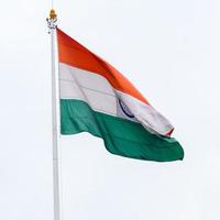 India flag flying high at Connaught Place with pride in blue sky, India flag fluttering, Indian Flag on Independence Day and Republic Day of India, tilt up shot, Waving Indian flag, Har Ghar Tiranga photo