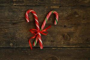 Closeup of two old fashioned candy canes on a rustic wooden background photo