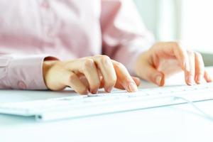 Woman office worker typing on the keyboard photo