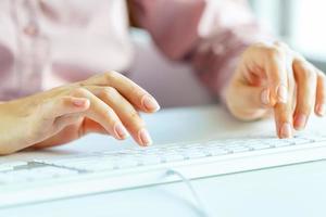 Woman office worker typing on the keyboard photo