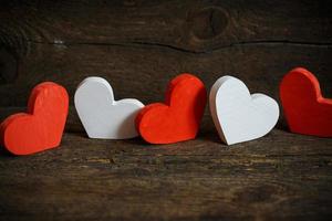 Red and white hearts on old shabby wooden background photo