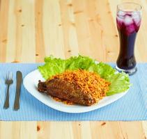 Dishes from turkey meat with rice and salad leaves and a glass of juice with ice photo