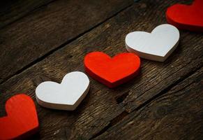 Red and white hearts on old shabby wooden background photo