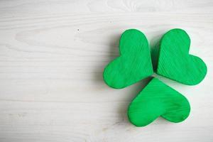 Green shamrock clovers on white wooden background photo