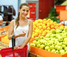 mujer compras en un supermercado en el Departamento de Fruta y vegetales foto