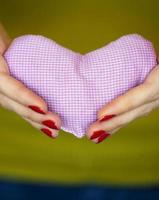 Closeup on pink heart in hand of woman photo