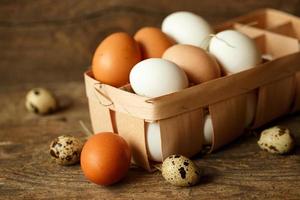 Chicken and quail eggs on a wooden rustic background photo