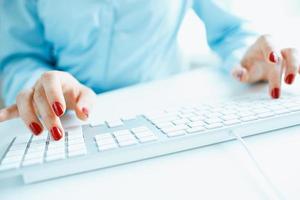 Woman office worker typing on the keyboard photo