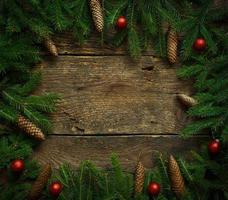 Christmas tree branches with cones and christmas decorations on wooden texture ready for your design photo