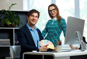 Beautiful young woman and man working from home photo