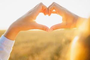 Hands heart symbol over the sunset photo