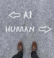 Man looking down at the words Artificial Intelligence - AI - and Human chalked onto the floor photo