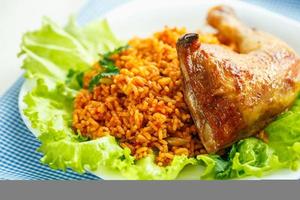 Delicious dishes from chicken thigh with rice and salad leaves photo