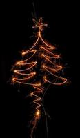 Christmas tree made by sparkler on a black photo