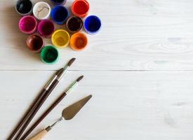 Watercolors and paint brush on white wooden background photo