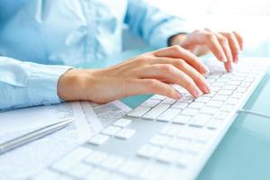 Woman office worker typing on the keyboard photo