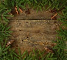 Christmas tree branch with cinnamon sticks and dittany on wooden texture with copyspace photo