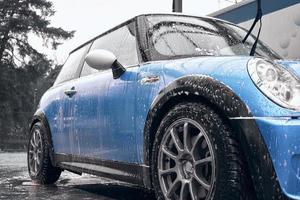 Hand wash with soap, pink foam on the body. Car washing with high pressure water. photo