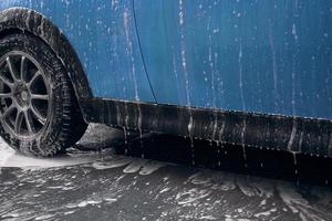 Hand wash with soap, pink foam on the body. Car washing with high pressure water. photo