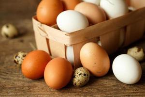 Chicken and quail eggs on a wooden rustic background photo