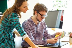 Young colleague looking to a color paint palette at home office, modern business concept photo