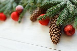 Christmas tree branches with cones, christmas decorations on white wooden texture ready for your design photo