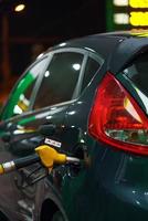 Car refueling on a petrol station in winter at night photo