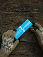 Female hands in winter gloves with christmas gift box photo