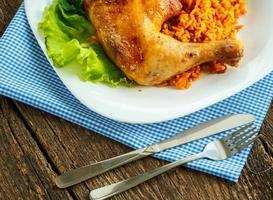 Delicious dishes from chicken thigh with rice and salad leaves photo