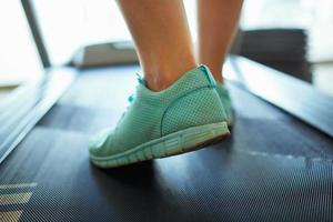 Foot of woman running on treadmill photo