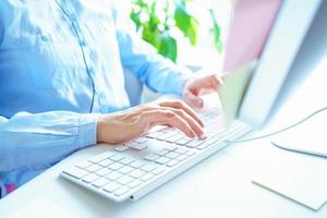 Woman office worker typing on the keyboard photo