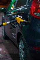 coche repostaje en un gasolina estación a noche foto