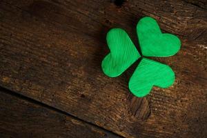 Green shamrock clovers on wooden background photo