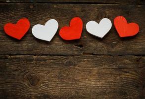 Red and white hearts on old wooden background photo