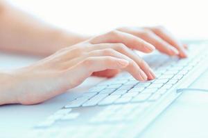 Female hands or woman office worker typing on the keyboard photo