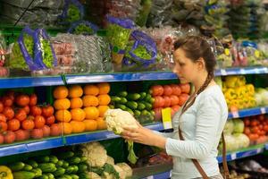 hermosa joven mujer compras para cereal, abultar en un tienda de comestibles Tienda foto