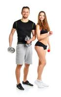 Athletic man and woman with dumbbells on the white photo