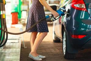 Woman fills petrol into her car photo