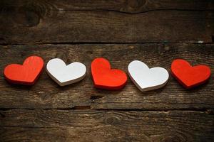 Red and white hearts on old shabby wooden background photo