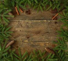 Christmas tree branch with cinnamon sticks and dittany on wooden texture with copyspace photo