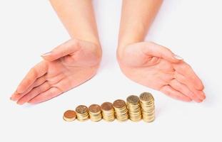 Womens arms around columns of coins photo