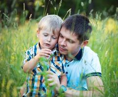 padre y su bebé hijo teniendo divertido en el parque al aire libre foto