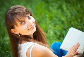 Beautiful girl with book in the park close up photo