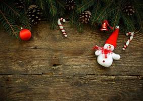 Navidad árbol ramas con Navidad decoraciones y monigote de nieve en de madera textura foto